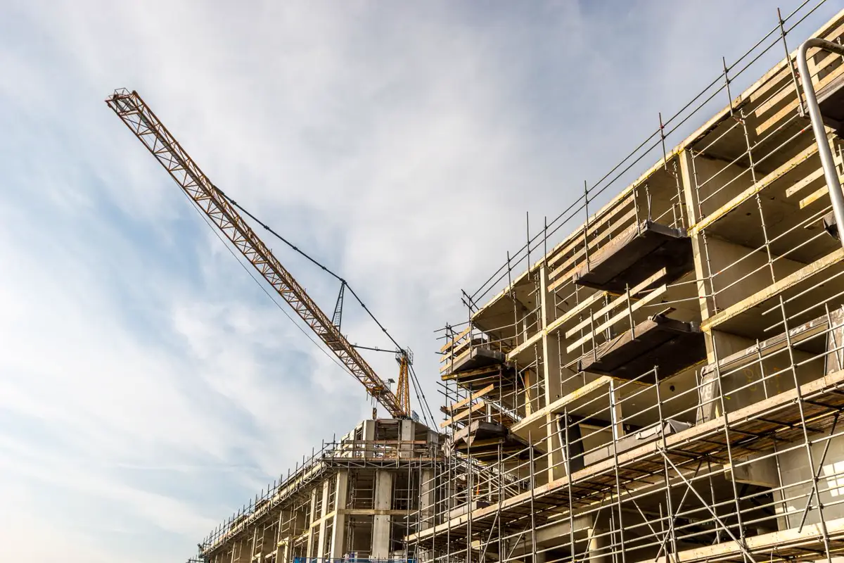 Edificio en construcción con andamios y una grúa